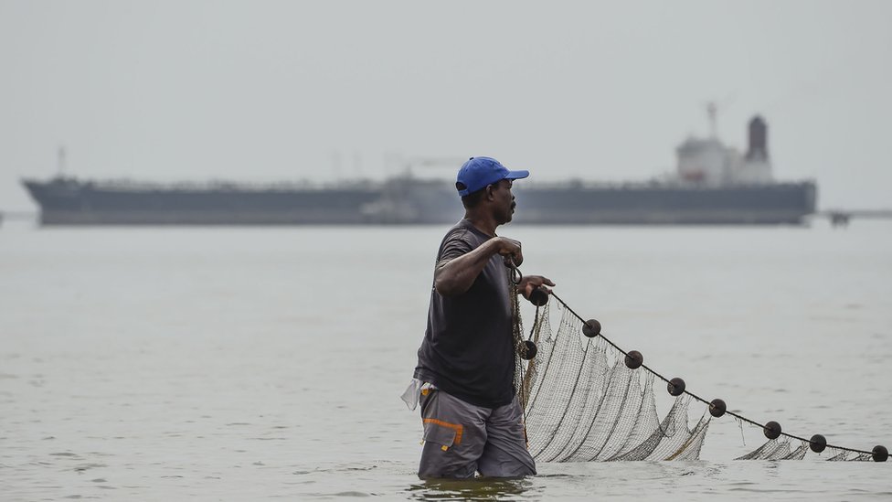 Рыбак тянет сеть в озере Маракайбо в венесуэльском городе Маракайбо, 15 марта 2019 года.