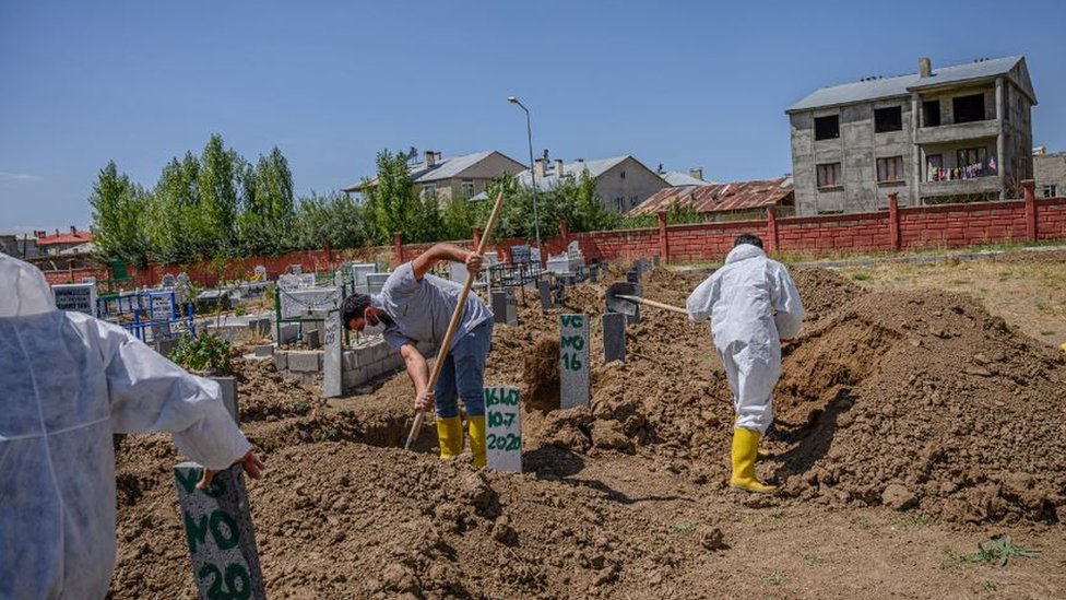 Рабочие хоронят тела неопознанных жертв, извлеченных из озера Ван