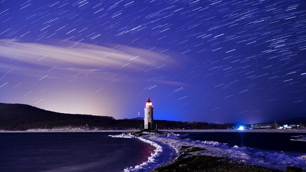 Hujan meteor Gemini di langit mercusuar Dokarevsky di Eckersheld Cape Bay di Pulau Rusky di Laut Jepang.