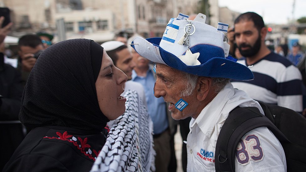 A pro-Palestinian woman and a pro-Israeli man shouting at each other