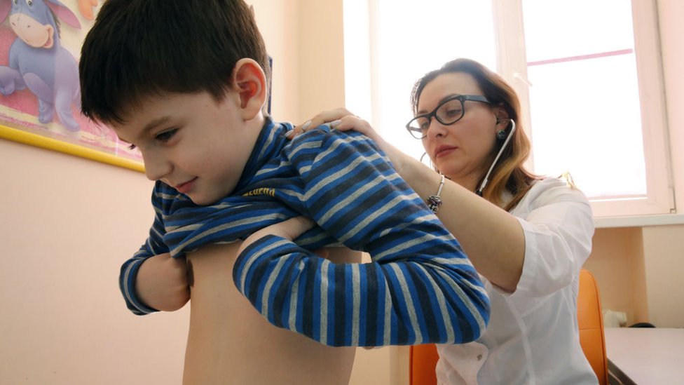 Pediatra revisando a un niño