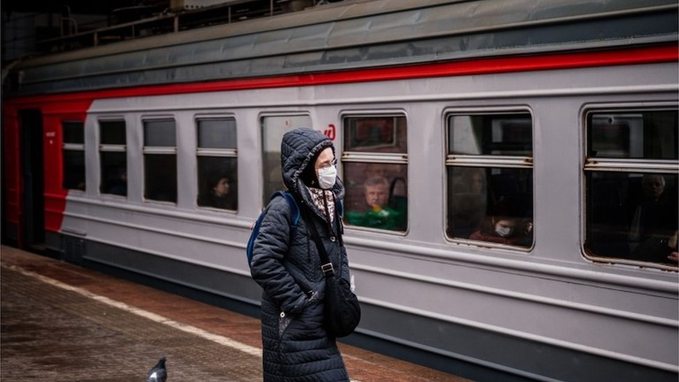 Una persona frente a un tren del metro de Moscú