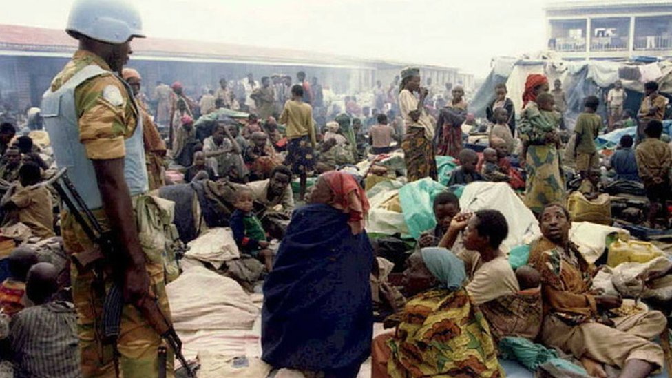 Миротворец ООН стоит у входа в лагерь беженцев Кибехо в Руанде