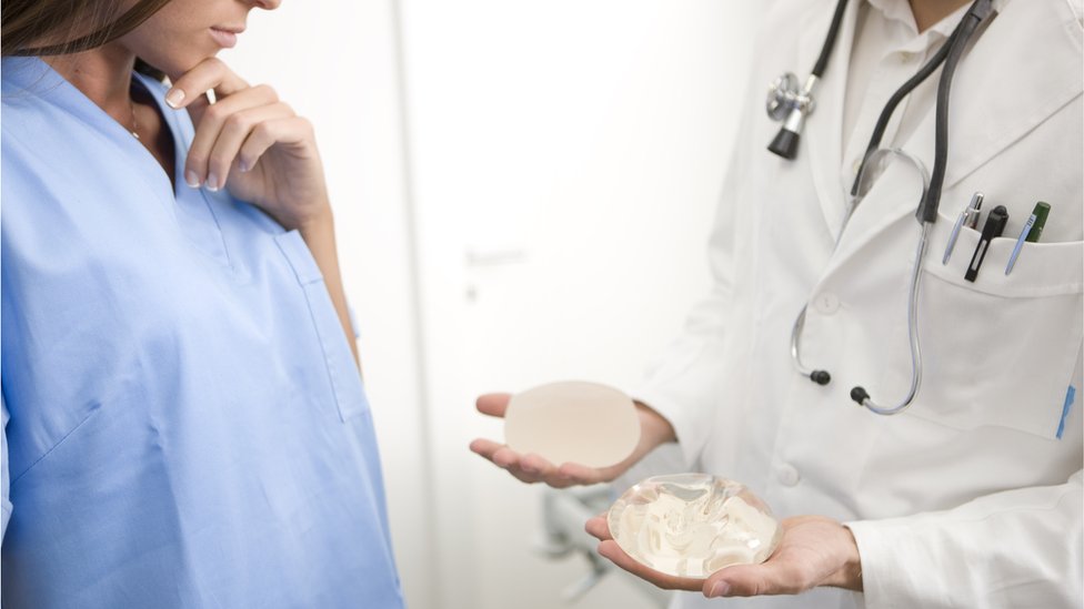 Para quienes estén considerando ponerse un implante la FDA recomienda hablar con el médico de los riesgos y beneficios asociados al procedimiento. Mujer considerando distintos implantes de mama