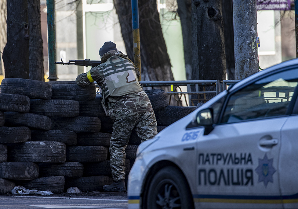 Un soldado ucraniano, en posición de defensa tras una barrera de neumáticos en Kiev.