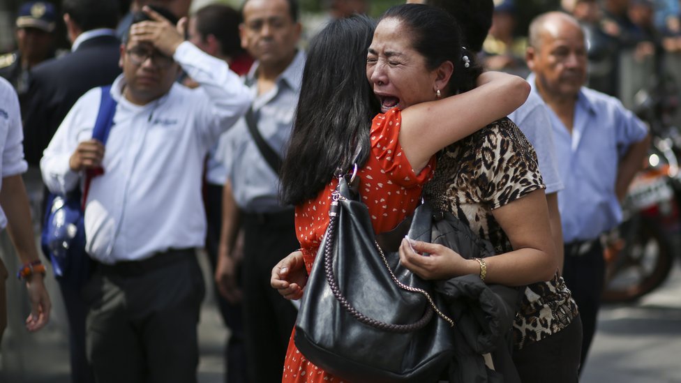 Две женщины обнимаются и плачут на улице в Мехико