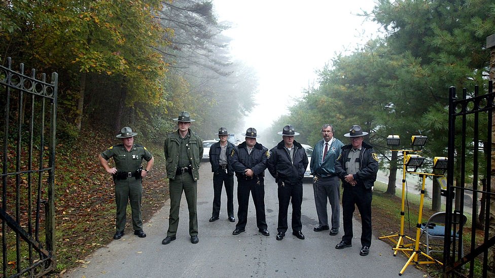 Law enforcement officers stand at the entrance to the Alderson Federal Prison Camp where Martha Stewart turned herself in October 8, 2004