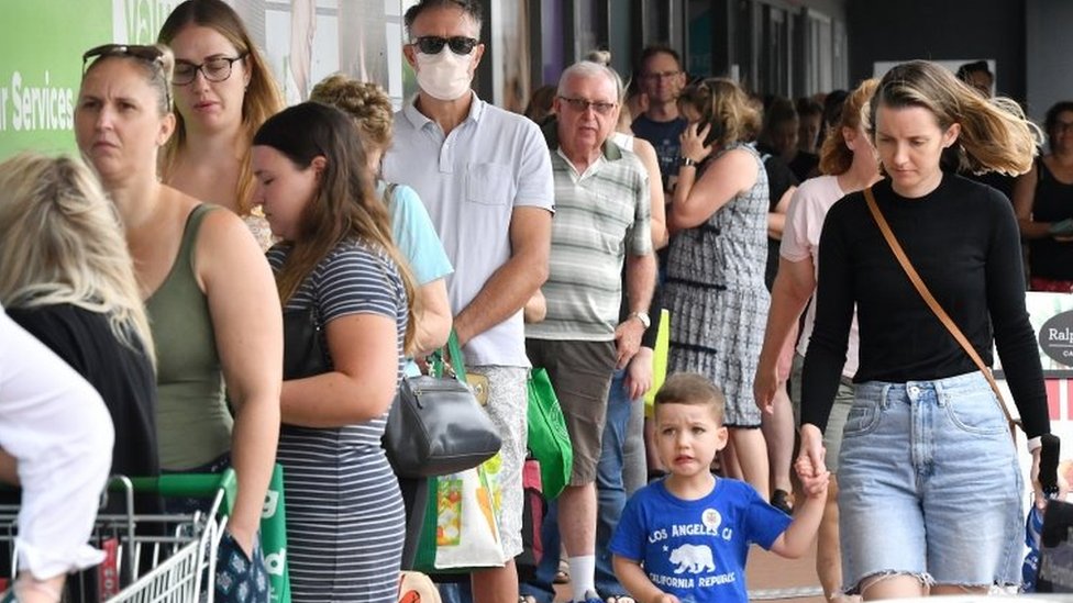 Люди стоят в очереди за продуктами возле супермаркета в Брисбене в пятницу