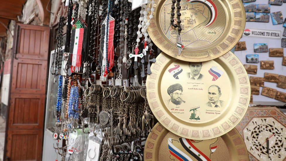 طبق في سوق سوري، نقشت عليه صور الأسد ونصر الله وبوتين
