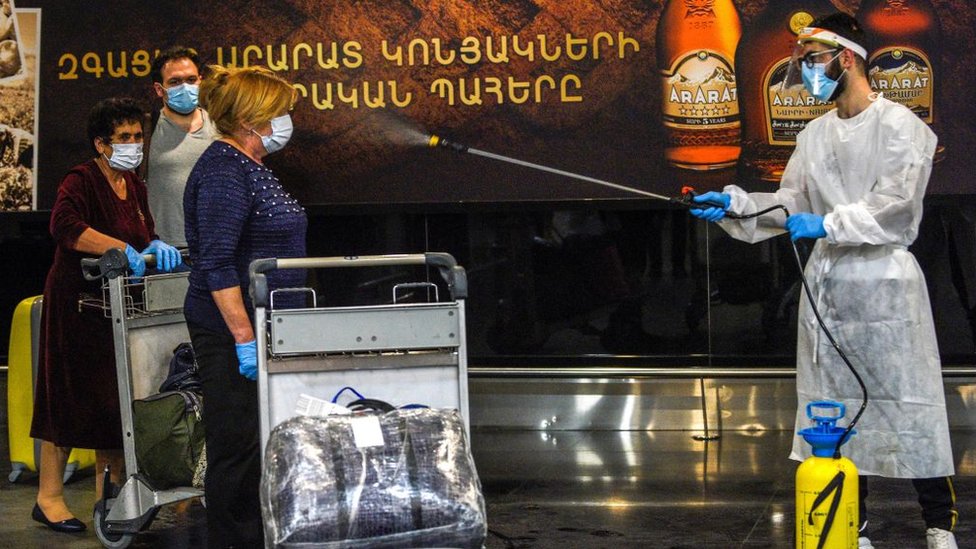 Медицинские работники опрыскивают прибывших в аэропорт Еревана, Армения