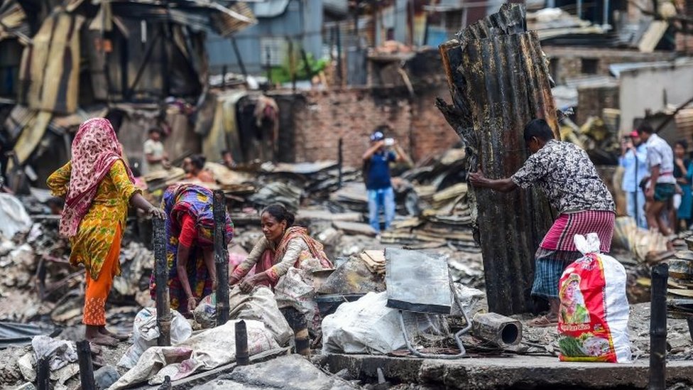 Жители ищут домашнее имущество в трущобах в Дакке 18 августа 2019 года,