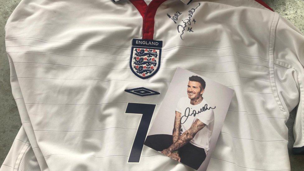 Дэвид Бекхэм подписал фотографию и футболку Англии.
