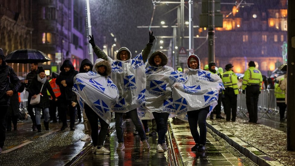 Sejumlah orang mengenakan jas hujan saat perayaan tahun baru di Edinburgh.