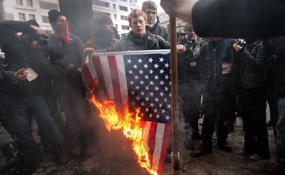 Анархисты сжигают американский флаг [Звезды и полосы] после парада инаугурации президента США Джорджа Буша на второй срок 20 января 2005 года в Вашингтоне, округ Колумбия