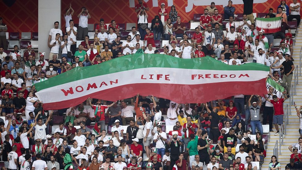Iranian fans raise a banner reading 'woman, life, freedom' during the Qatar 2022 FIFA World Cup Group B match between England and Iran at the Khalifa International Stadium on November 21, 2022 in Doha, Qatar
