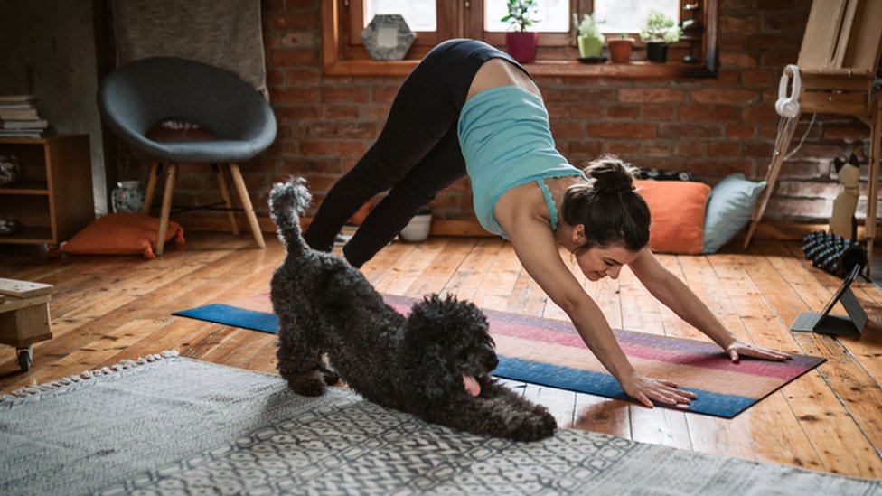 Una mujer haciendo ejercicio en compañía de su perro.