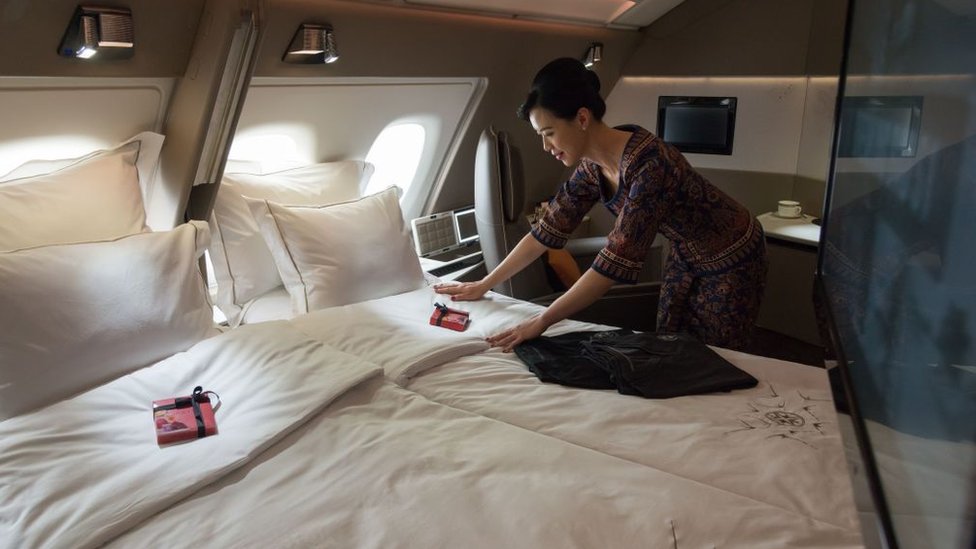 Azafata tiende la cama en avión de Singapore Airlines