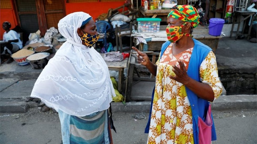 Женщины в масках болтают на рынке Нима, в то время как Гана снимает частичную изоляцию на фоне распространения коронавирусной болезни (COVID-19) в Аккре, Гана, 20 апреля 202 г.