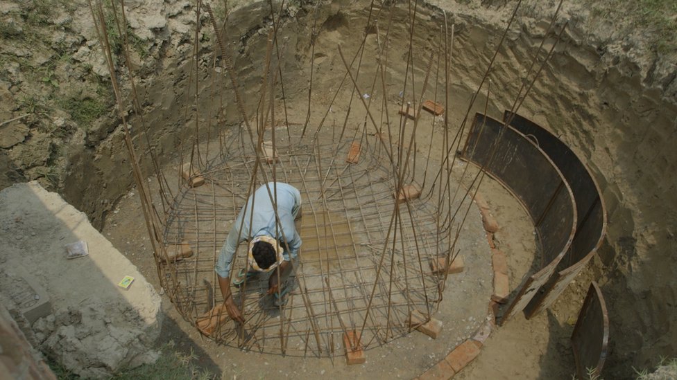 Человек в большой дыре строит биореактор с железными проволоками
