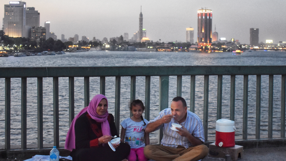 Семья ест на мосту через реку Нил в Каире, Египет