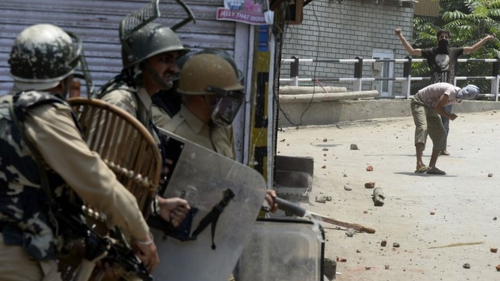 Кашмирские протестующие (справа) бросают камни в индийские правительственные силы во время столкновений в Сринагаре (8 июля 2017 г.)