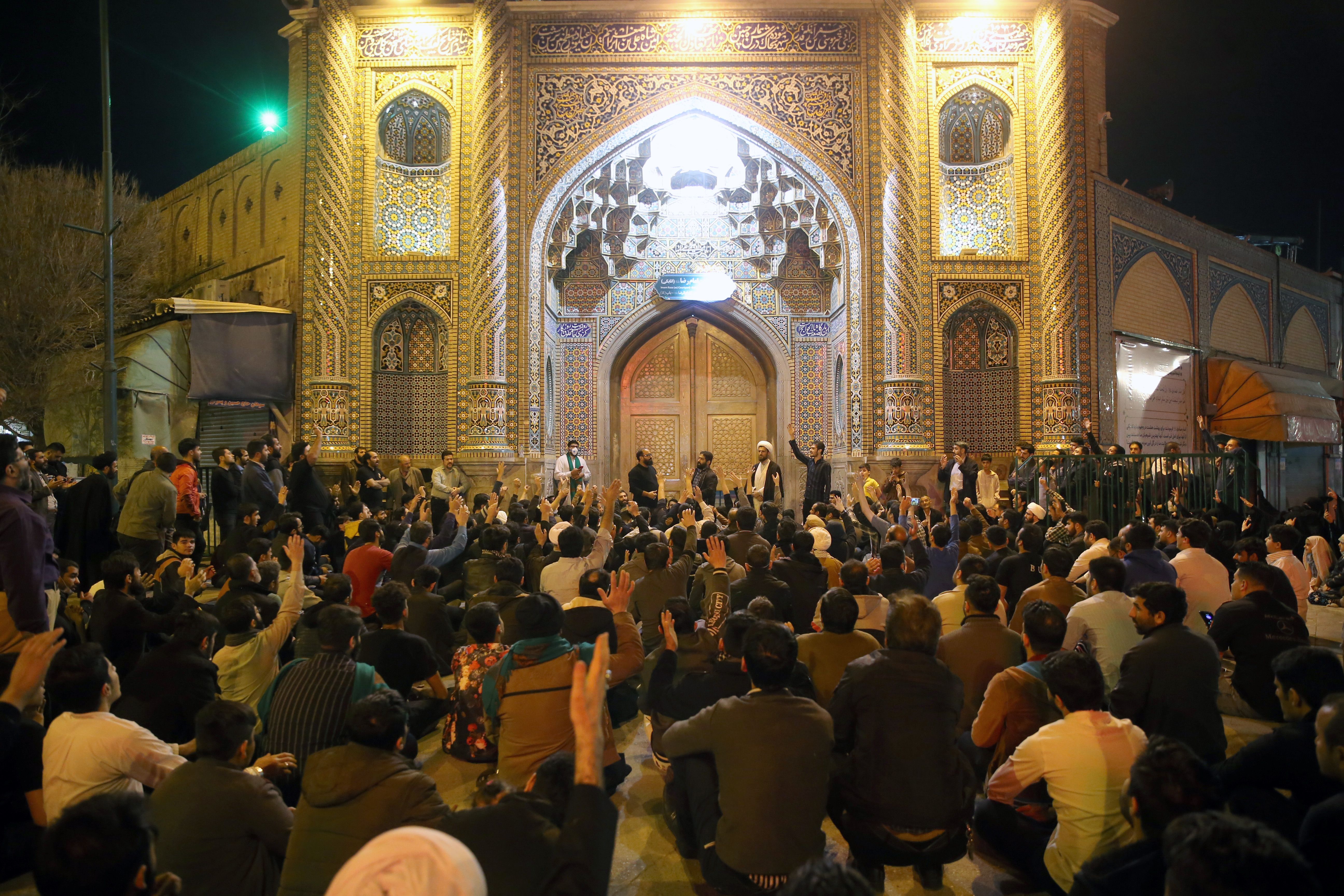 Люди собираются у закрытых дверей храма Фатима в священном городе Ирана Кум