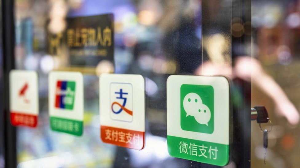 Etiquetas de WeChat y de otras apps de pago en la puerta de un comercio.