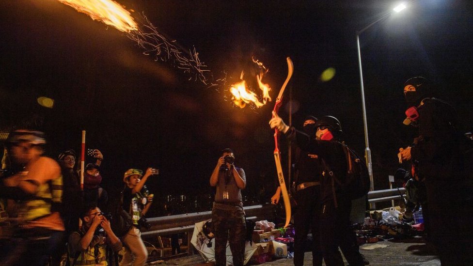 Manifestante lanza una flecha con fuego. Manifestante lanza una flecha con fuego.