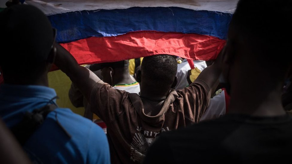 Una persona con una bandera rusa durante una manifestación para celebrar el anuncio de que Francia iba a retirar sus tropas de Malí.