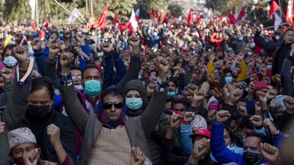 Активисты-коммунисты Непала держат кулаки во время акции протеста против роспуска парламента в Катманду, Непал