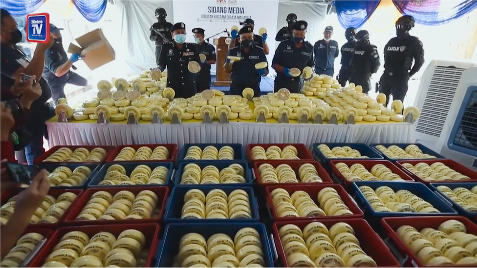 رجال الشرطة الماليزية وفي حوزتهم كمية ضخمة من حبوب الكبتاغون تم ضبطها