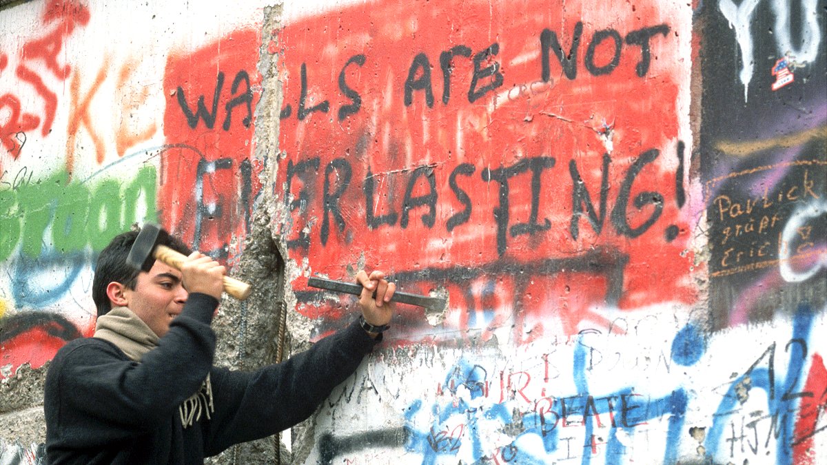 Hombre tallando el Muro de Berlín, 1989. Dice "Los muros no son eternos"