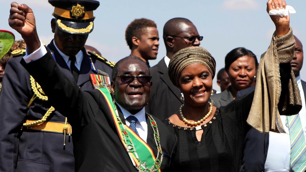 Президент Зимбабве Роберт Мугабе (слева) и его жена Грейс (справа) приветствуют сторонников на национальном митинге в честь Дня героев в Хараре, 11 августа 2014 г.