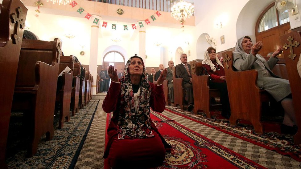 Muchos cristianos iraquíes son caldeos, un rito católico oriental con autonomía respecto a Roma pero que reconoce la autoridad del Papa. Una mujer reza en una iglesia católica en Irak.