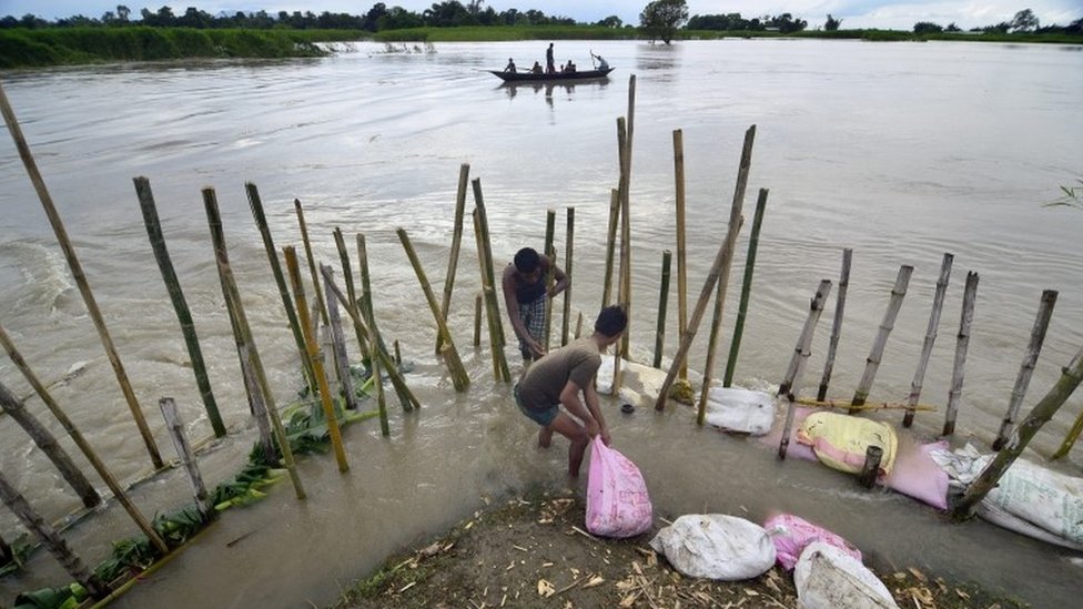 Жители деревни ремонтируют насыпь с бамбуком и мешками с песком, которую смыло наводнение в результате наводнения, пострадавшего от района Моригаон штата Ассам, Индия, 2 сентября 2015 г.