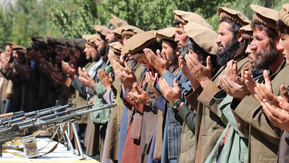 Группа солдат Талибана молится после того, как пожертвовала своим оружием и присоединилась к афганскому правительству