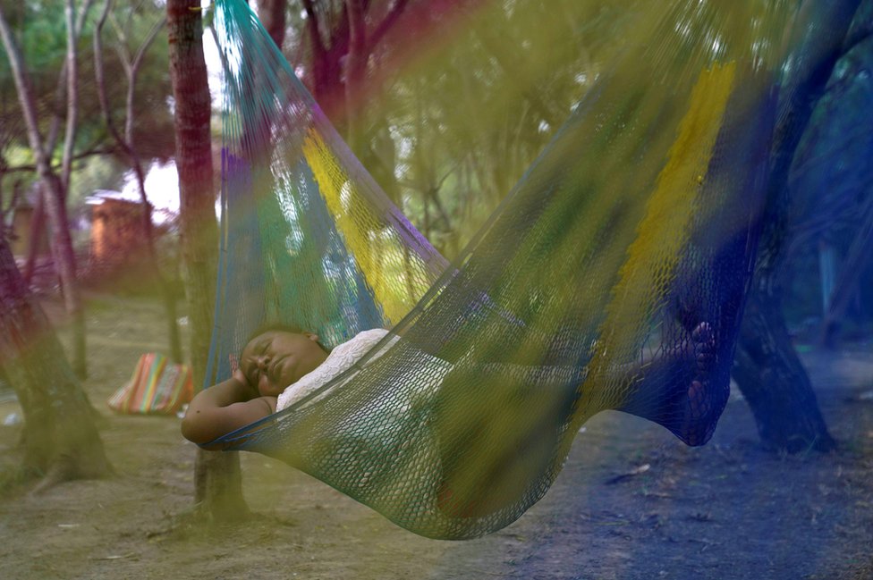 A Mexican asylum-seeking woman sleeps in a hammock