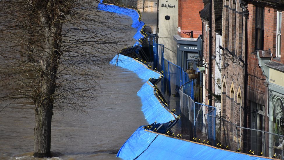 Временные барьеры от наводнений, которые были перенесены рекой Северн в сторону пристани в Айронбридже