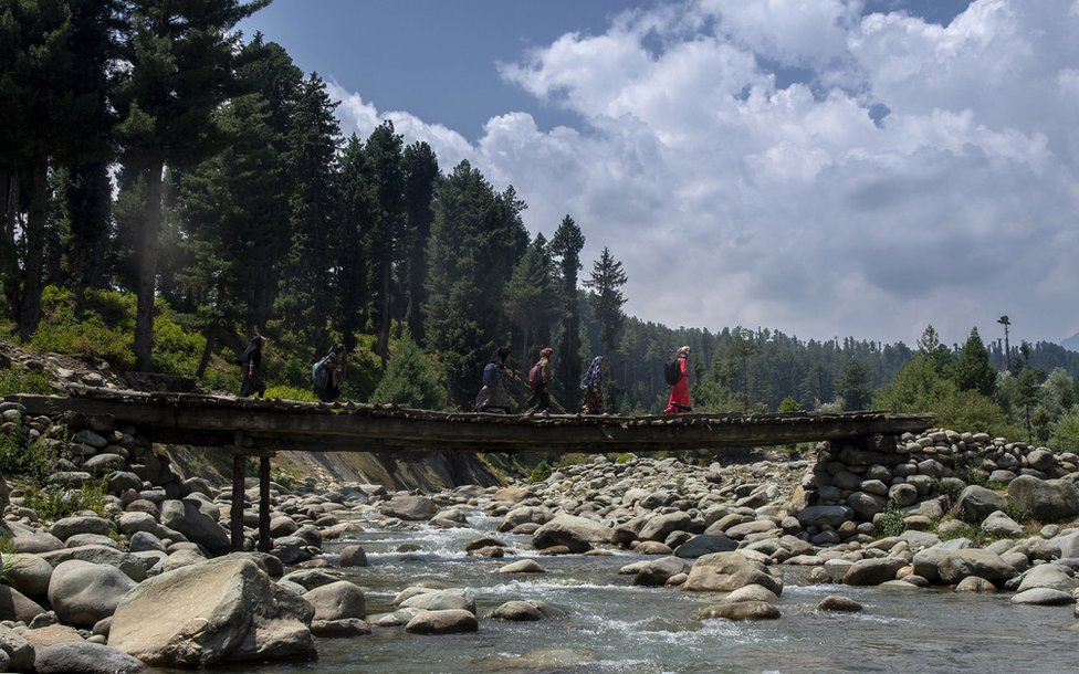 Школьники идут в школу по мосту в Кашмире.