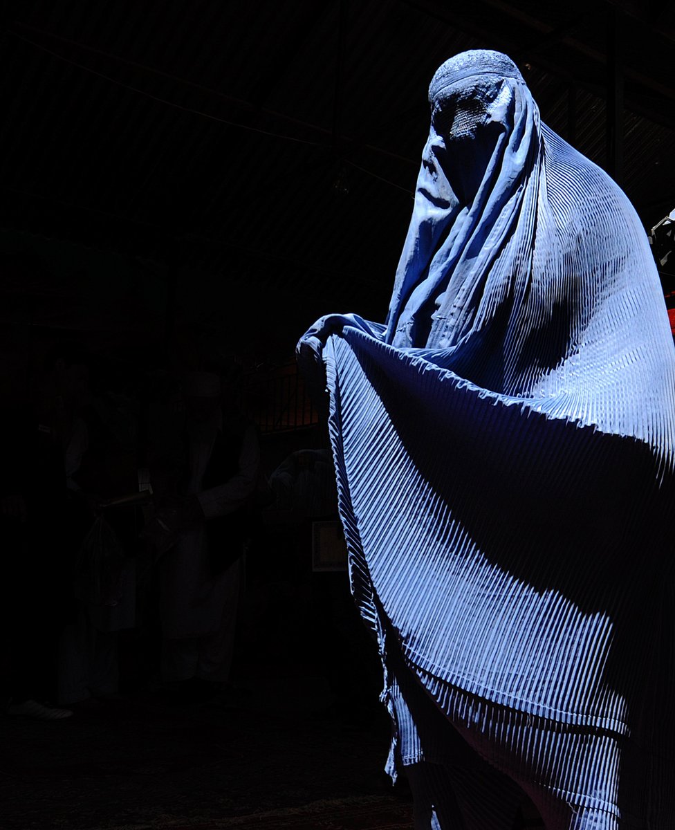 A supporter of Afghan presidential candidate Abdullah Abdullah, one of the 41 contenders in the upcoming election, makes her way to a campaign event in Kabul on 4 August 2009