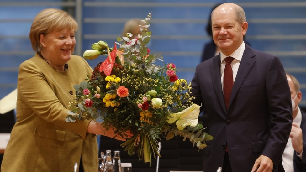 Angela Merkel porta una corona de flores en presencia de Olaf Scholz.