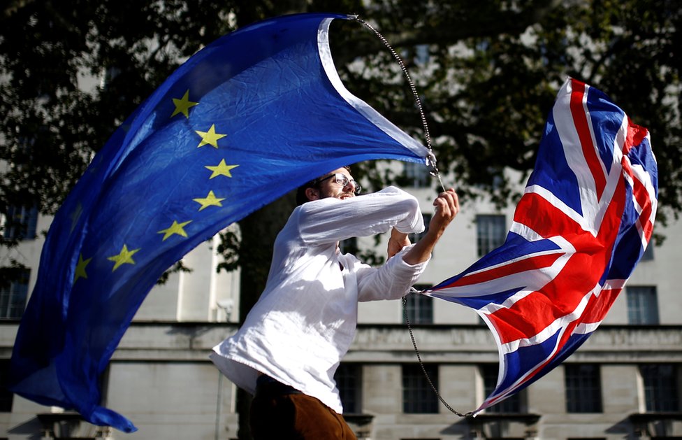 Мужчина машет флагами ЕС и союза в Вестминстере в Лондоне