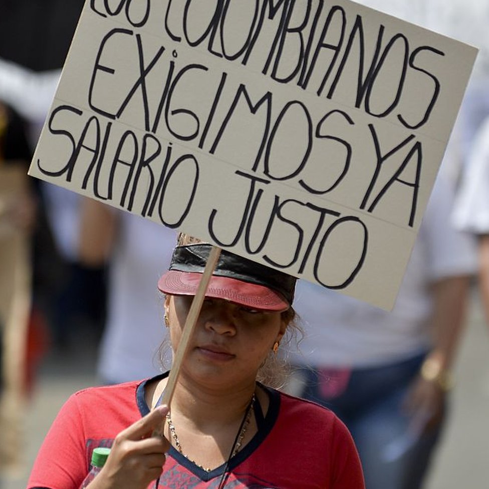 Una mujer sostiene una pancarta con la que pide un salario justo durante una manifestación contra la política económica del entonces presidente Juan Manuel Santos, el 25 de enero de 2016, en Cali, Colombia.