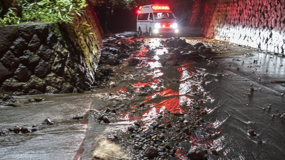 Автомобиль скорой помощи проезжает через завалы по затопленной дороге во время эвакуации гостей в отеле Osen Sanso Nakamura в Сенгокухара, провинция Наконе, Япония, 12 октября 2019 г.