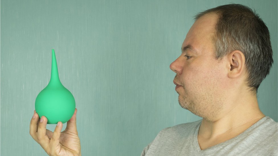 Hombre mirando a un enema
