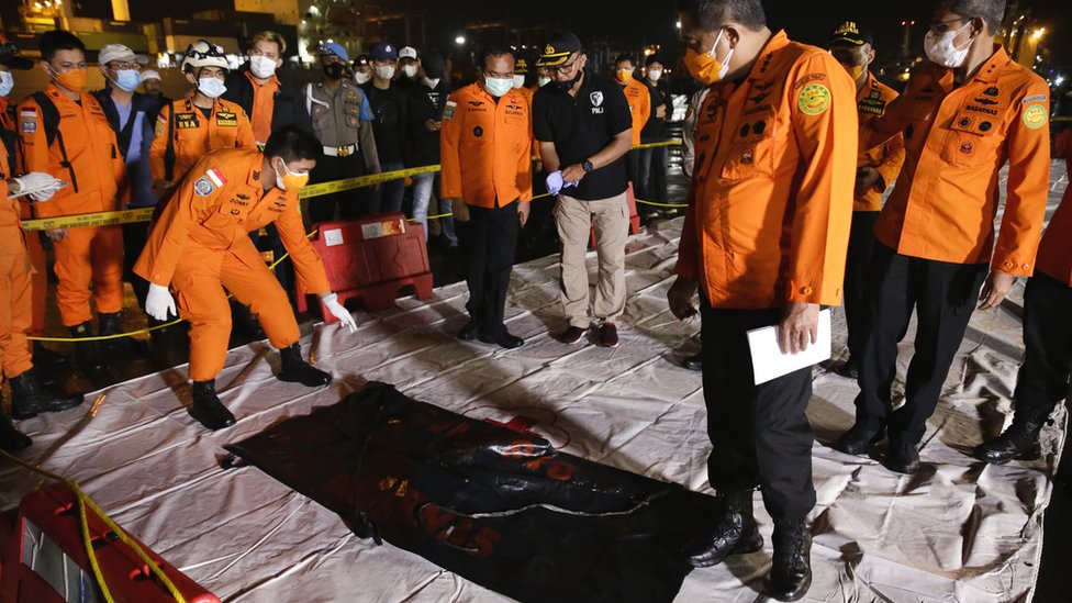 Indonesian search and rescue officers inspect a bag with wreckage believed to be of the missing Sriwijaya Air plane, at Tanjung Priok port in Jakarta, Indonesia, 10 January 2021