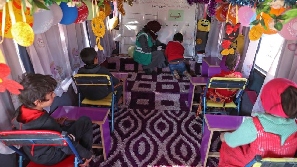 Children learning inside a bus
