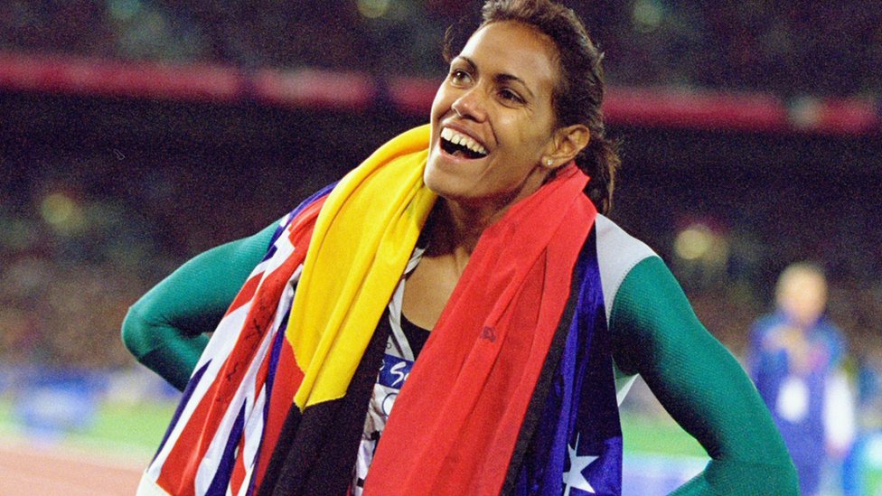 Cathy Freeman wearing the Aboriginal and Australian flags after her win at the Olympics in 2000