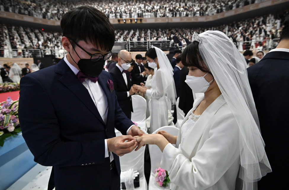 الأزواج يتبادلون خواتم الزواج في حفل زفاف جماعي نظمته كنيسة التوحيد في غابيونغ
