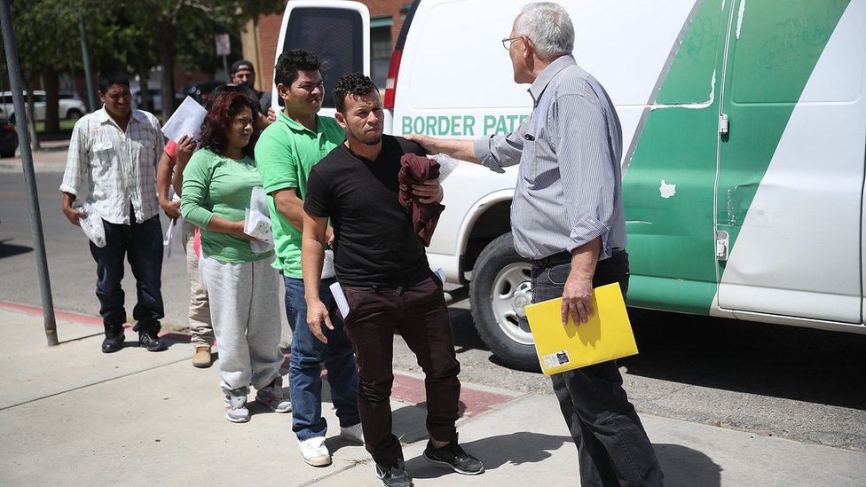 Padres migrantes bajando de un bus